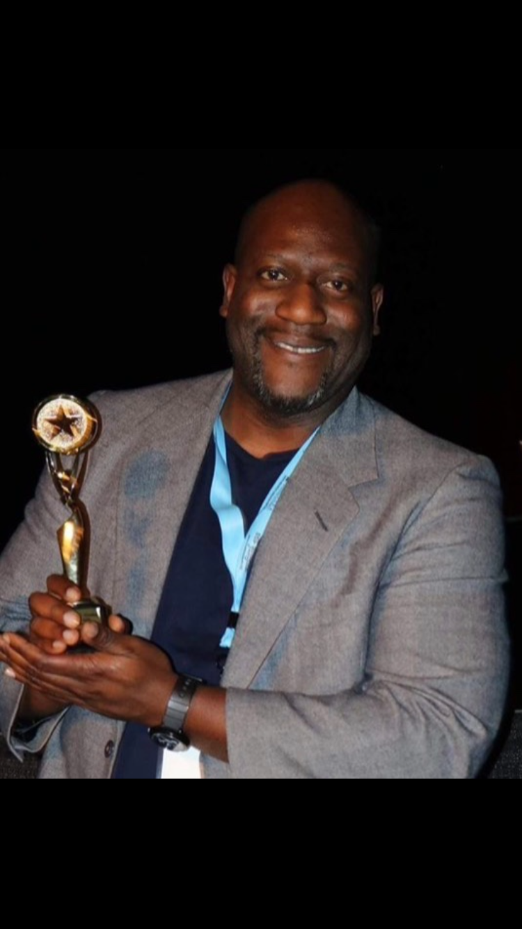 Tomike Ogugua holding an award